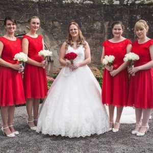 photo of bride wearing white and 4 bridesmaids in scarlet